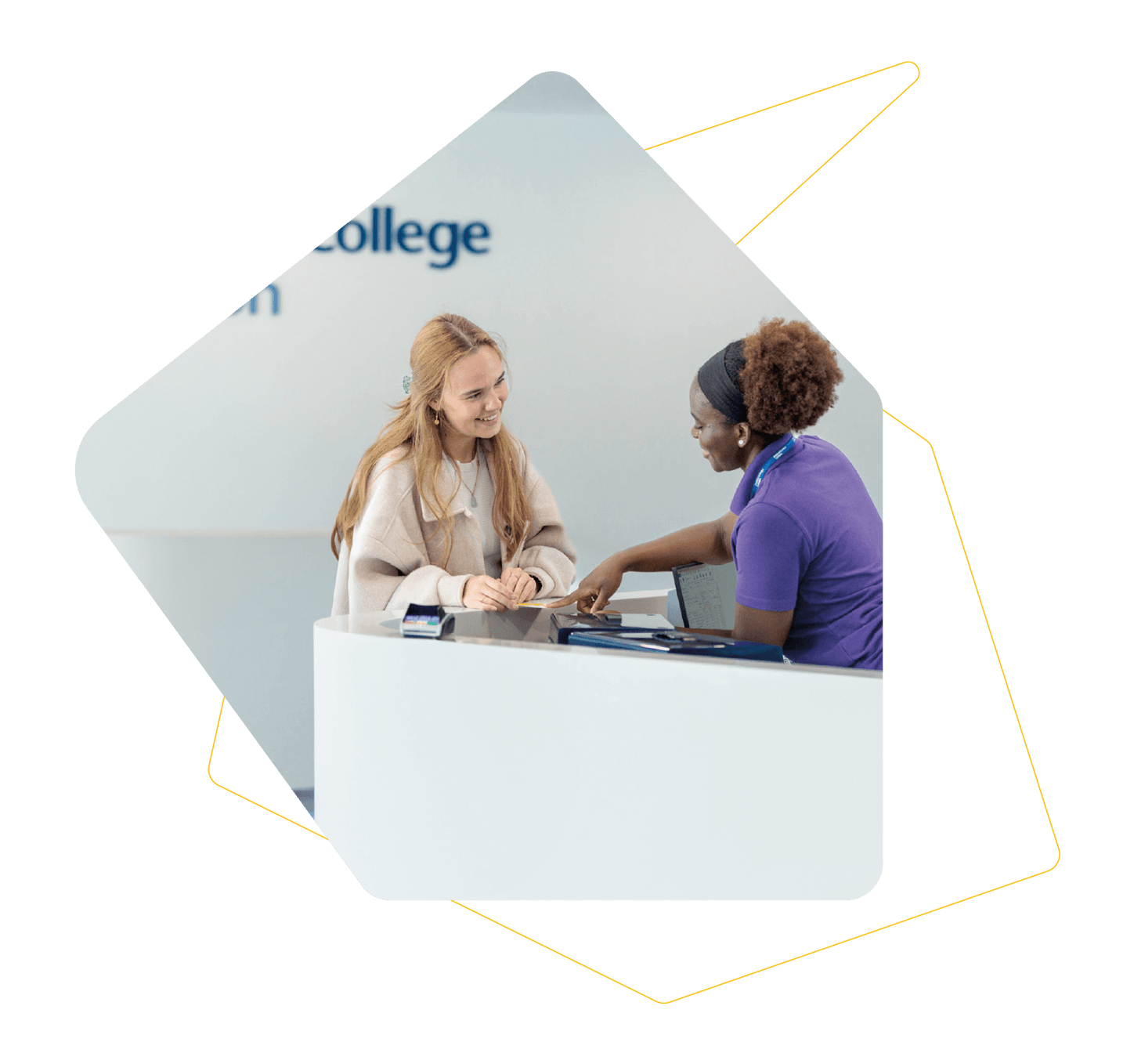 Two women chatting at a desk with the Imperial College London logo on the wall behind them