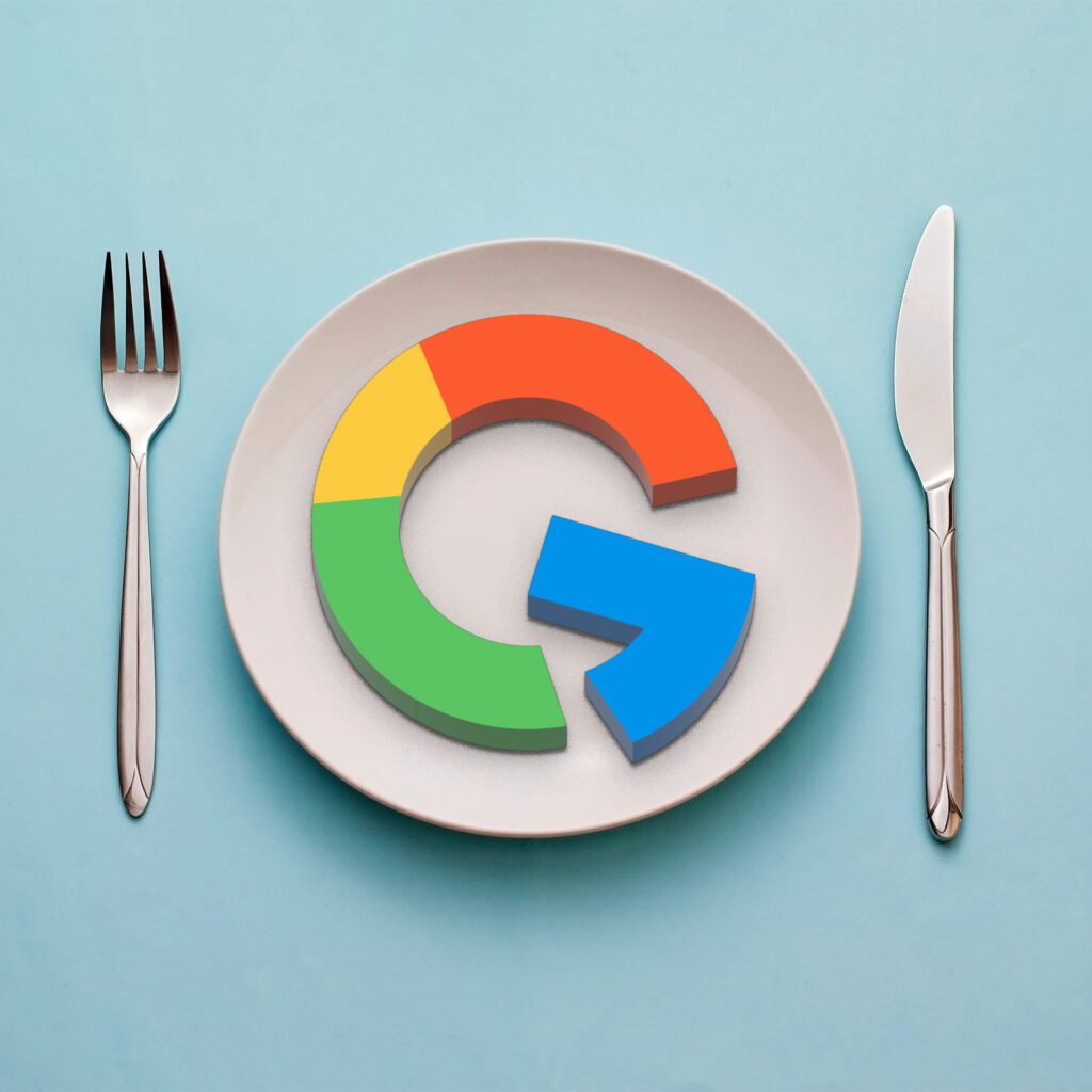 Plate with the google logo cake on it, with a slice taken out of it