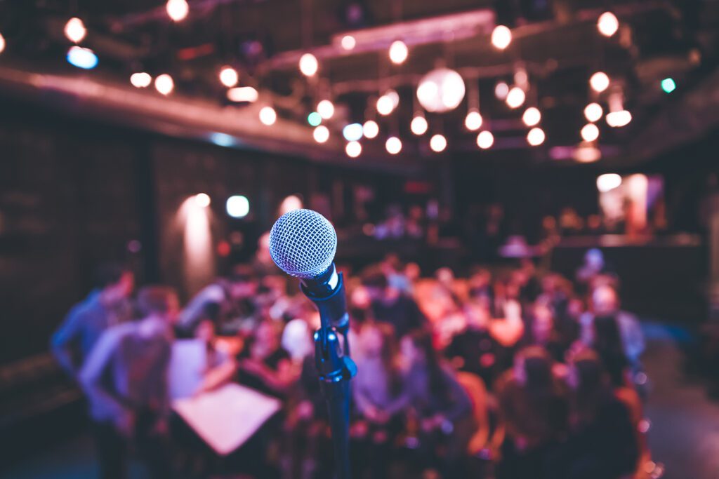 Microphone stand in a busy pub, audience in the blurry background