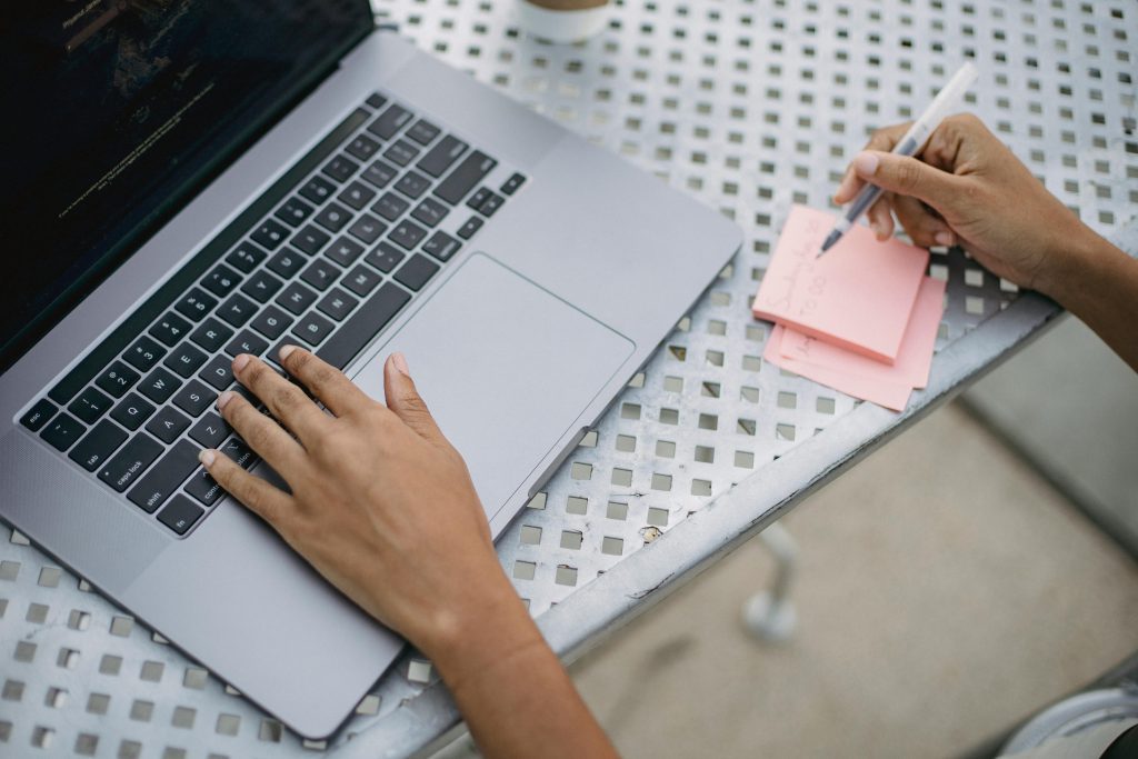 Laptop and hand writing on a post-it note