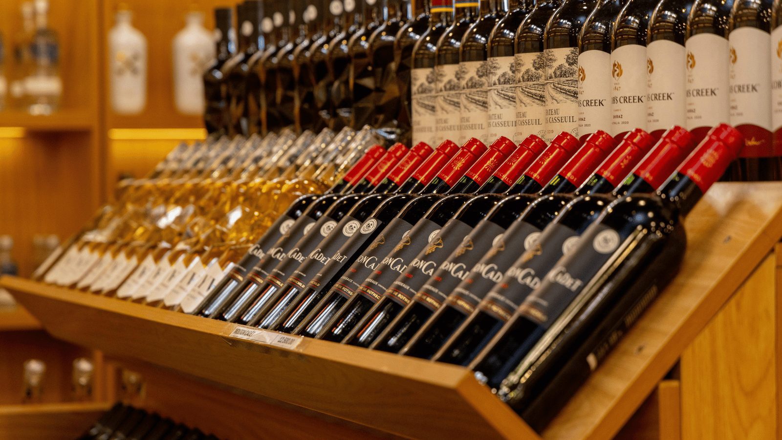Close up of red and white wine bottles laying next to eachother.